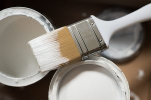 tins of paint and a paintbrush