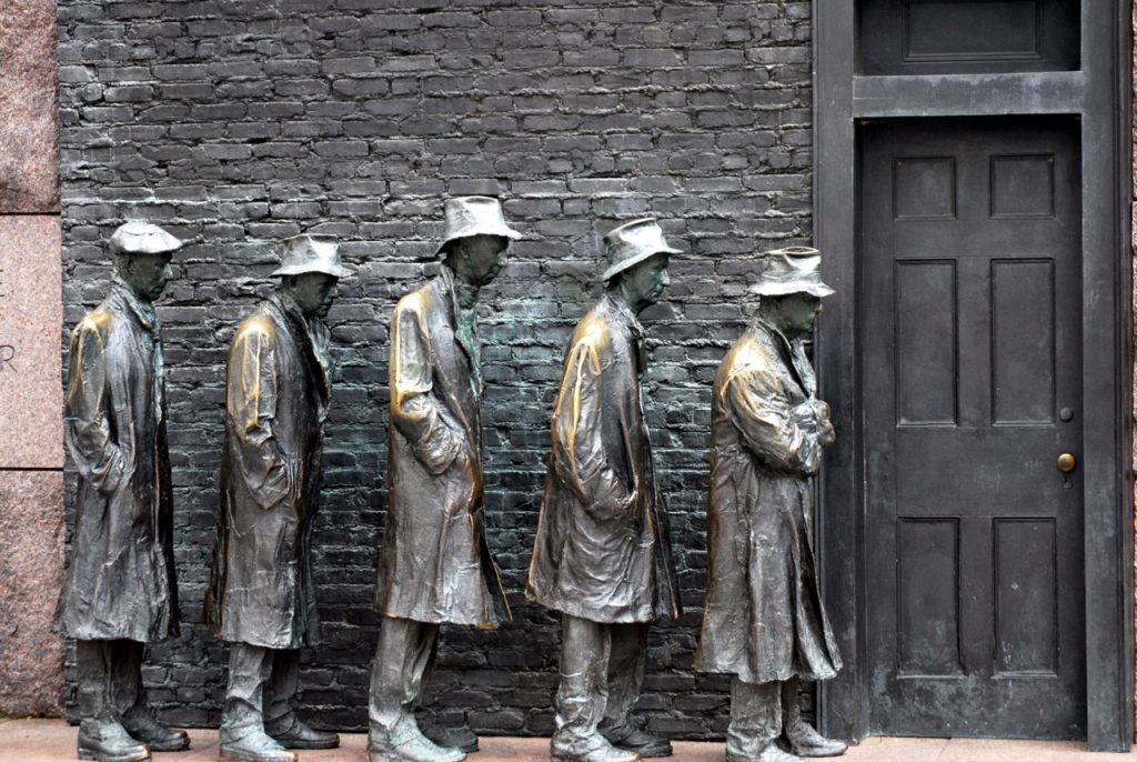 A culpture depicting 5 men in 30s garb waiting in line at a closed door